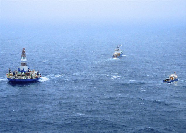The tugs Aiviq and Nanuq tow the mobile drilling unit Kulluk while a Coast Guard MH-60 Jayhawk helicopter from Air Station Kodiak delivers parts to the tug Aiviq crew so they can make engine repairs while underway 80 miles southwest of Kodiak City, Alaska, Saturday, Dec. 29, 2012. The tug lost the initial tow Thursday and suffered several engine failures prompting the deployment of response assets by the Coast Guard and Royal Dutch Shell. U.S. Coast Guard photo by Petty Officer 1st Class Sara Francis.