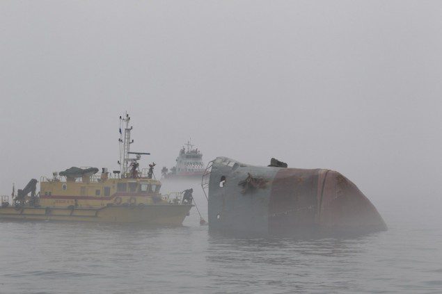 Rescuers travel in a boat as they search for survivors amidst heavy fog near a sunken barge, south of Hong Kong April 19, 2013. REUTERS/Apple Daily